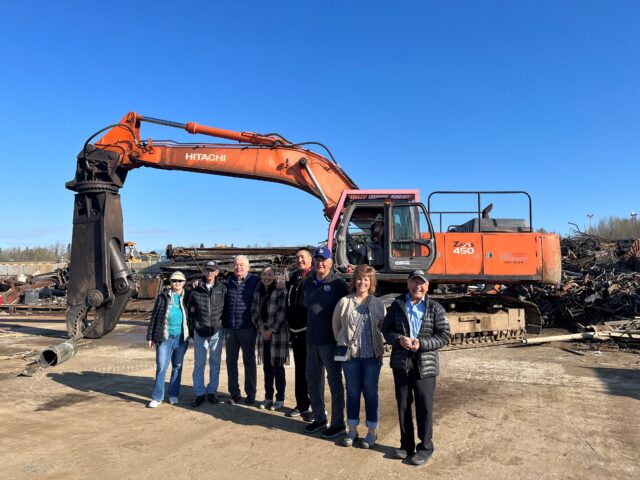 group of people in front of large equipment